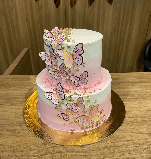 Bolo de dois andares rosa com borboletas e pérolas douradas