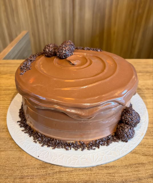 Bolo de chocolate com cobertura cremosa e brigadeiros
