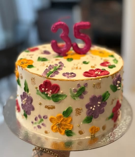 Bolo com flores pintadas à mão e velas de 35 anos