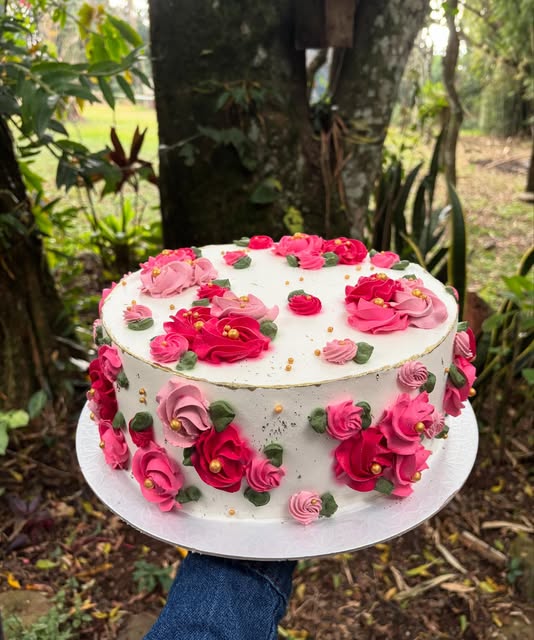 Bolo branco decorado com rosas de chantilly em tons de pink