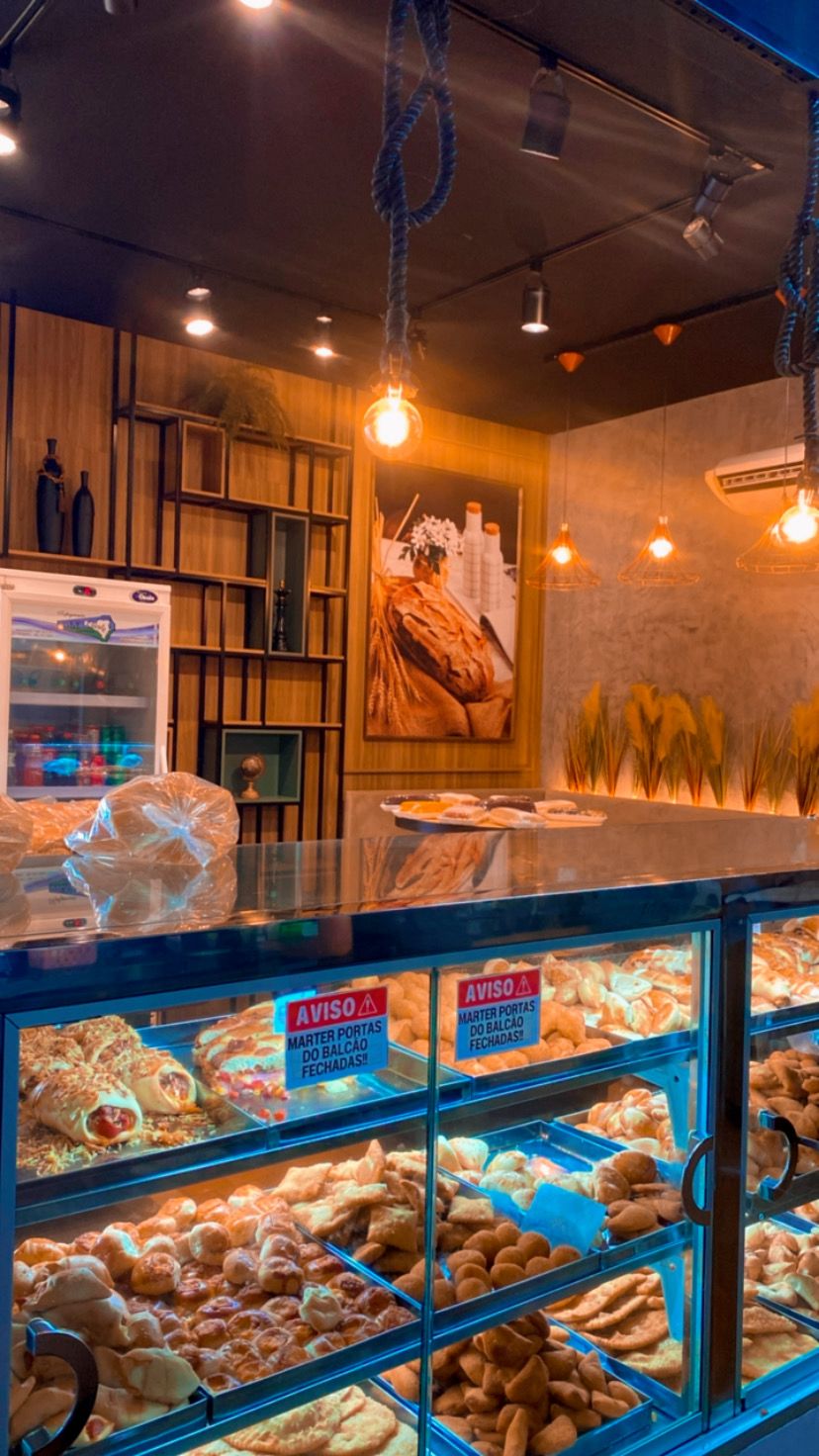 Vitrine de salgados iluminada no balcão do Empório do Pão